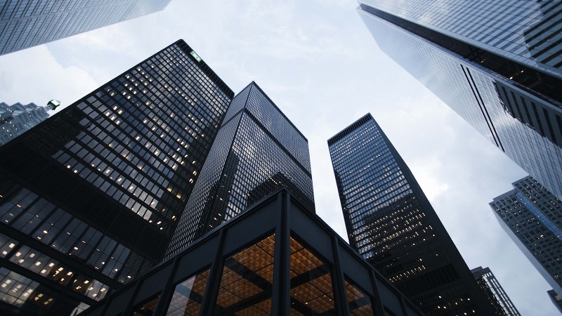 Glass office towers seen from street level against a clear sky